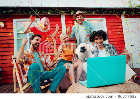 Happy friends of football fans watching soccer on laptop and celebrating victory 96377682