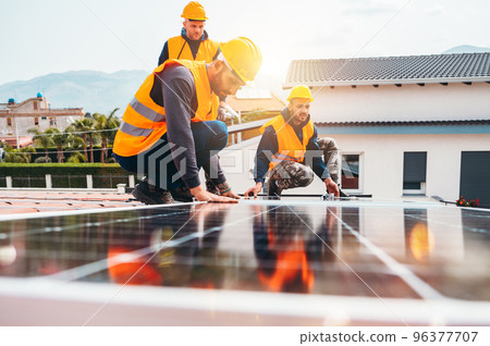 Workers assemble energy system with solar panel for electricity 96377707