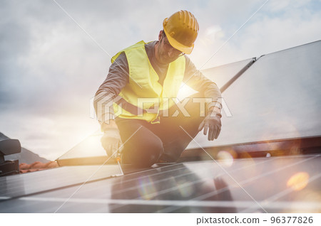 Man works on renewable energy system with solar panel for electricity and hot water 96377826