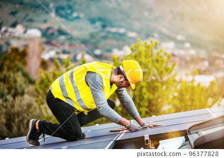 Workers assemble energy system with solar panel for electricity 96377828