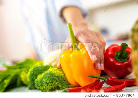 Woman in the home kitchen prepares a genuine dish with fresh vegetables 96377904
