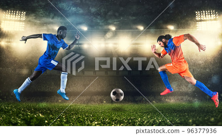 Two soccer players challenge each other chasing the ball at the stadium 96377936