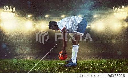Soccer scene at night match with player in white and uniform placing the ball to kick Soccer scene at night match with player in white and uniform placing the ball to kick 96377938