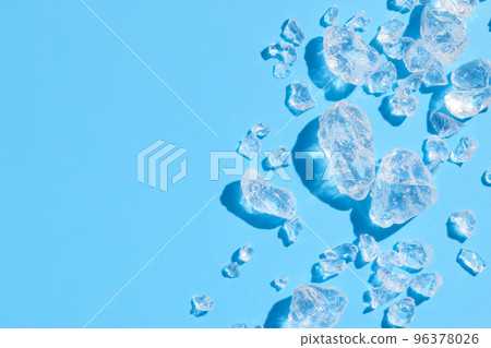 Close up crushed ice in sunlight on blue with copy space. Summer background refreshment concept 96378026