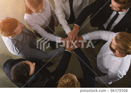 Business people putting their hands together as teamwork and partner 96378506