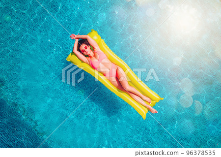 Girl in swimsuit who tan in a swimming pool 96378535
