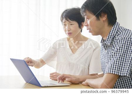 Mature couple using a computer at home Mature couple using a computer at home 96379945