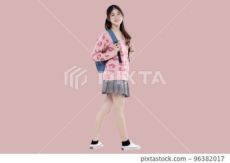 Happy Asian ethnicity teen girl hold backpack standing isolated on pastel pink background. Education in high school college concept. 96382017