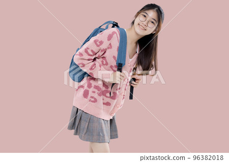 Happy Asian ethnicity teen girl hold backpack isolated on pastel pink background. Education in high school college concept. 96382018