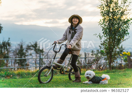 秋冬，亞洲女人帶著狗在露營地騎自行車 96382527