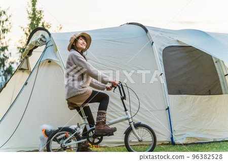秋冬，亞洲女人帶著狗在露營地騎自行車 96382528