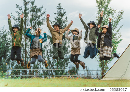 Fellows and friends jumping at the campsite in autumn and winter 96383017