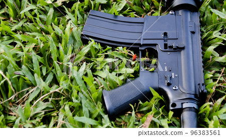 Close up some parts of air soft gun put on the grass 96383561
