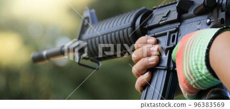 Air soft gun holding by hands in the shooting range, soft and selective focus on the gun                               96383569
