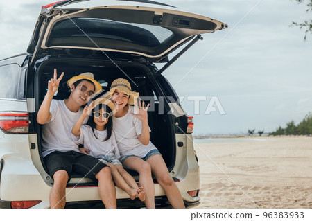 Tourism Day. Family having fun in summer vacation on beach show V-sign finger. Parents and kid family travel in holiday at sea beach. Father, Mother and daughter enjoying road trip sitting on back car Tourism Day. Family having fun in summer vacation on beach show V-sign finger. Parents and kid family travel in holiday at sea beach. Father, Mother and daughter enjoying road trip sitting on back car 96383933