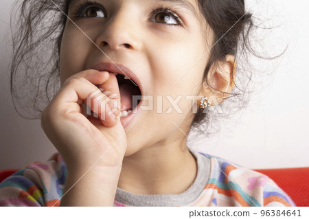 Little girl portrait trying to remove loose milk-tooth Little girl portrait trying to remove loose milk-tooth 96384641