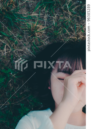 一名年輕女子躺下看書的照片 96385289