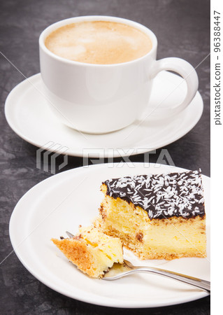 Fresh baked cheesecake and cup of coffee with milk. Delicious dessert Fresh baked cheesecake and cup of coffee with milk. Delicious dessert 96388447