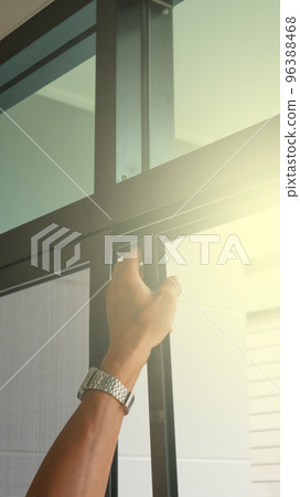 Technician inspects a window frame which is new installed a mosquito wire screen 96388468
