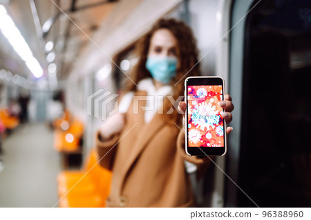 Girl in protective sterile medical mask in the subway car. Woman, wear face mask, protect of virus Girl in protective sterile medical mask in the subway car. Woman, wear face mask, protect of virus 96388960