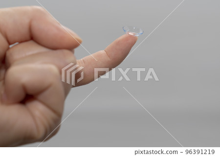 (材料)戴在右手食指上的軟性隱形眼鏡照片 (材料)戴在右手食指上的軟性隱形眼鏡照片 96391219