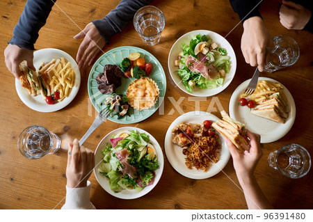 Hands of women eating at a girls' association 96391480