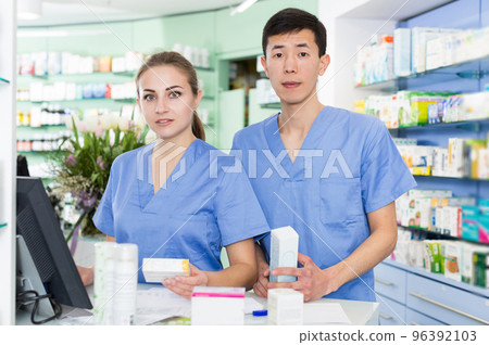 Female and male specialist are attentively stocktaking medicines Female and male specialist are attentively stocktaking medicines 96392103