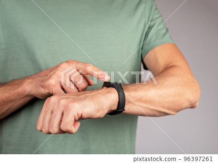 Man wearing fitness tracker and checking health metrics. Device for physical activity monitoring. Healthy lifestyle concept Man wearing fitness tracker and checking health metrics. Device for physical activity monitoring. Healthy lifestyle concept 96397261