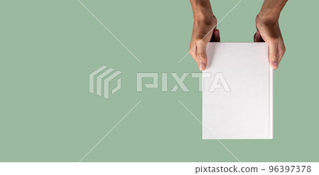 Banner with hand holding closed book mockup on green background in eco style. Template with blank cover about weather, nature, ecology, biology. Space for text 96397378