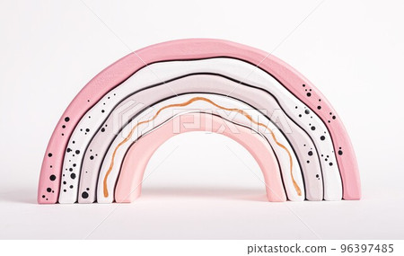 Wooden rainbow stacking toy from arcs in tender pink pastel colors. Imagination, motor skills, sense of comparison development. Abstract geometric shapes. Gift for children 96397485