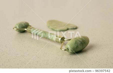 Gua Sha scraping massage tool and roller. Face beauty, skin care, relaxation concept. Traditional healing treatment Gua Sha scraping massage tool and roller. Face beauty, skin care, relaxation concept. Traditional healing treatment 96397542