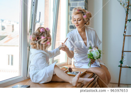 funny mom and daughter in curlers play . 96397653