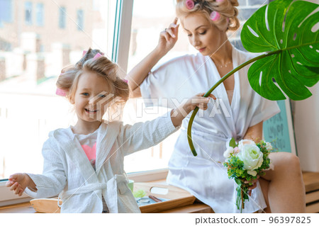 funny mom and daughter in curlers play 96397825