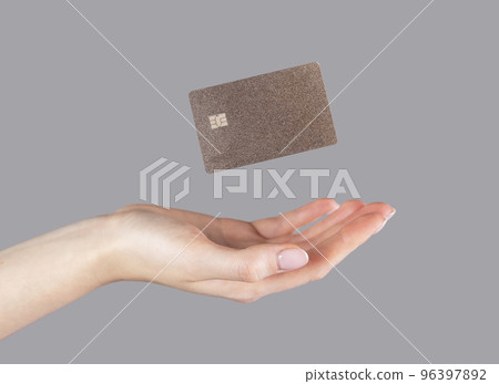 Woman hand and levitating plastic bank or debit card. Cashless payment and booking , making purchases on credit Woman hand and levitating plastic bank or debit card. Cashless payment and booking , making purchases on credit 96397892