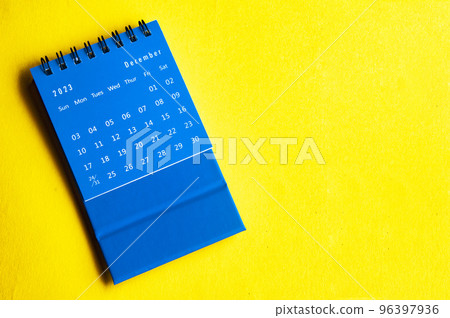 December 2023 blue desk calendar on yellow cover background with customizable space for text. Year end concept. 96397936