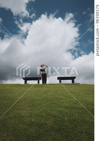 Happy young woman look at faraway when her relaxing in the park wiith clue sky and cloud Happy young woman look at faraway when her relaxing in the park wiith clue sky and cloud 96398578