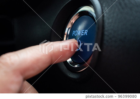 Hand push on car engine power start button close up 96399080