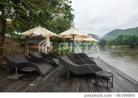 Relax seats by river in morning with mist in Kanchanaburi 96399668