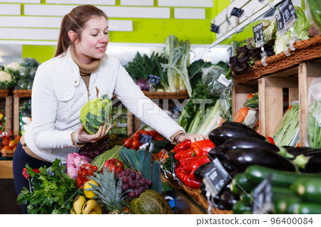 Young woman in greengrocery 96400084