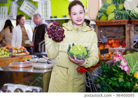 Glad little girl choosing fresh vegetables 96400095