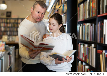 man with daughter looking for interesting books man with daughter looking for interesting books 96400211