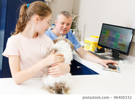 Smiling girl with puppy visiting veterinarian clinic Smiling girl with puppy visiting veterinarian clinic 96400332