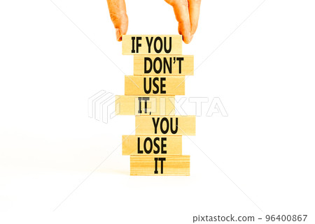 Use or lose symbol. Concept words If you do not use it you lose it on wooden blocks on a beautiful white table white background. Businessman hand. Business motivational and use or lose concept. 96400867