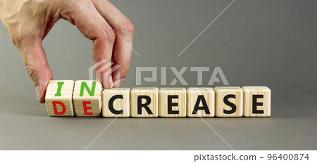 Increase or decrease symbol. Concept words Increase and Decrease on wooden cubes. Businessman hand. Beautiful grey table grey background. Business increase or decrease concept. Copy space. 96400874