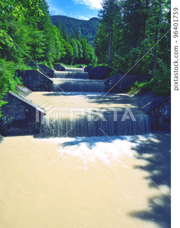Muddy river tributary from the peaks of the Dolomites Alps after heavy rain. The riverbed feeds the current to the hydroelectric power plant and on to the Walchensee 96401759