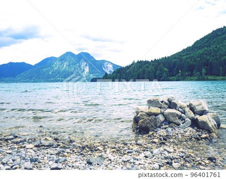 Balanced stones stacked in pyramid at lake water with Dolomite Alps reflection. Balanced stones stacked in pyramid at lake water with Dolomite Alps reflection. 96401761