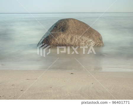 Round stone in the foreground on sandy beach. Baltic Sea at island 96401771
