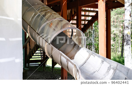 Children's slide in the form of a pipe in an amusement park. Recreation and entertainment concept 96402441