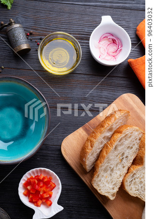 fresh ciabatta bread  with blue bowl and ingredients served at dark wooden table. meditarranean cuisine. flat lay 96403032