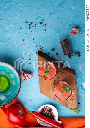 classic spanish raw eating cold soup Gazpacho served in glasses around blue background. food recipe. healthy concept. classic spanish raw eating cold soup Gazpacho served in glasses around blue background. food recipe. healthy concept. 96403163